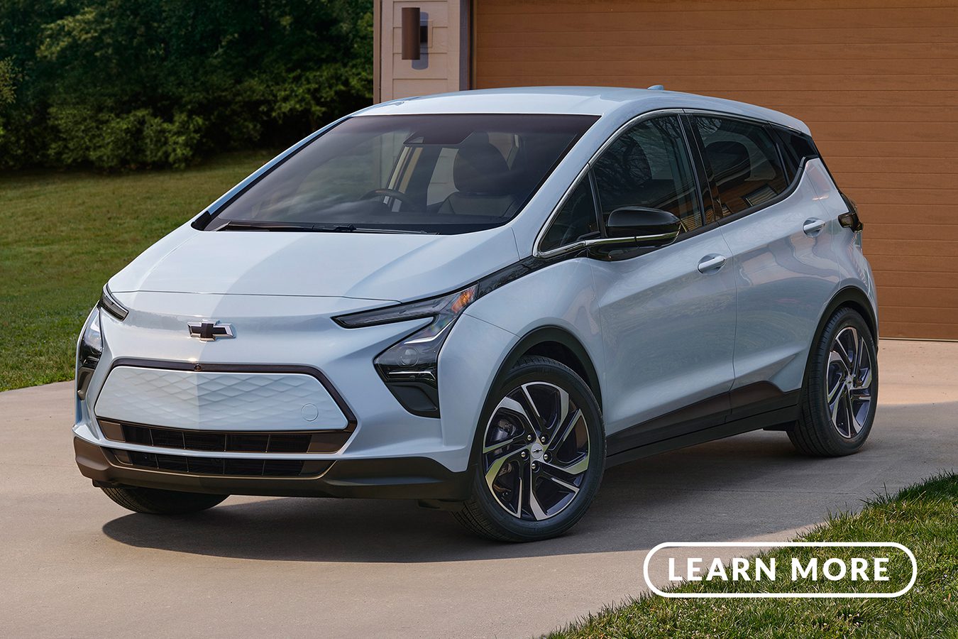 The 2020 chevrolet bolt parked in front of a garage.