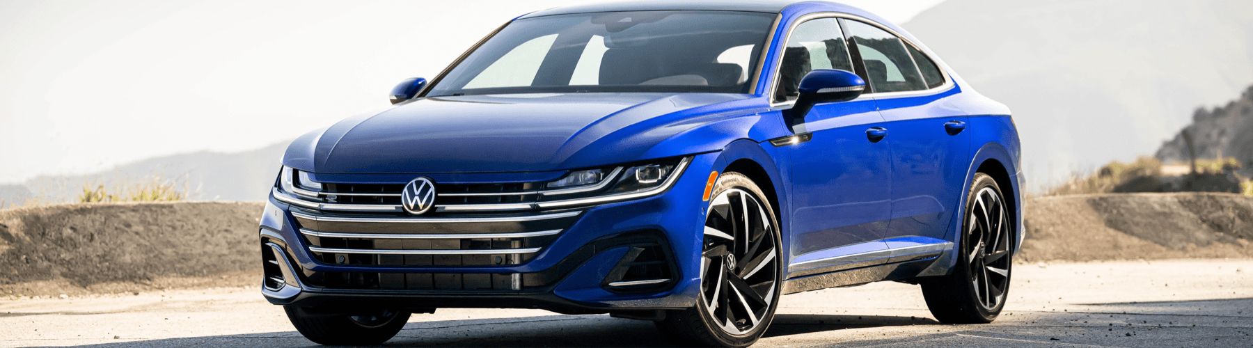 The 2020 volkswagen arteon is driving down a mountain road.