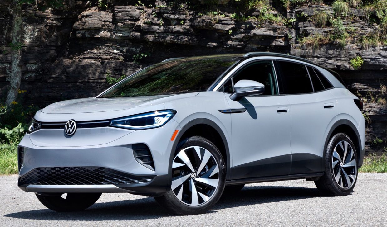 The 2020 volkswagen e - tron is parked in front of a rock.