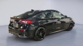 Black sporty sedan rear three-quarter view